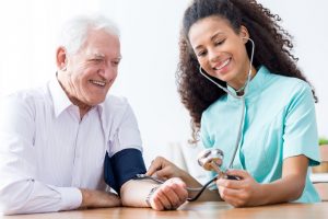 Smiling senior man having measured blood pressure
